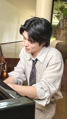 a man with black hair playing the piano