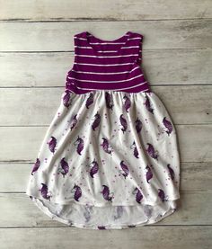 Welcome to Busy Bee Stitchery! This one of a kind 5T high-low dress will delight the little girl in your life. This dress is made from soft French Terry knit.  This dress will be a lovely addition to any little girl's wardrobe.  Pair it with a cute pair of leggings and boots!    All items are handmade by me in my smoke free, pet free studio, with love and attention to detail. All fabrics are prewashed and preshrunk before production. Since the fabrics are preshrunk you don't need to worry about them shrinking in the wash.   Recommended care of items is to machine wash on cold and tumble dry on low. Do not wash with heavy materials like jeans and towels. CPSC Compliant Become a Facebook fan here:  https://www.facebook.com/busybeestitcheryhandmade/ Follow us on Instagram at @busy.bee.stitche Playful Purple Sleeveless Dress, Cute Purple Sleeveless Dress, Whimsical White Sleeveless Dress, Sleeveless Unicorn Print Dress For Spring, Pink Sleeveless Dress With Unicorn Print, Cute Purple Sleeveless Sundress, Playful Sleeveless Unicorn Print Dress, Playful Summer Dresses With Unicorn Print, Fun Sleeveless Cotton Twirl Dress