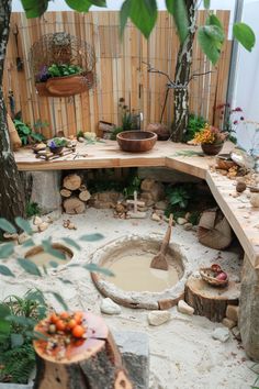 Rustic outdoor kitchen with wooden countertops, clay bowls, and a sandy floor surrounded by plants and logs. Outdoor Kitchen For Kids, Kitchen For Kids, Neutral Living Room Ideas, Mud Kitchen For Kids, Mud Kitchens, Play Area Backyard