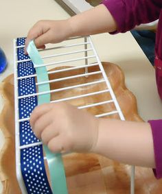 a young child is playing with a blue and white bow tie on a toy rack