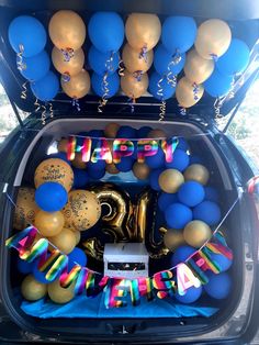 an open trunk filled with balloons and confetti for a happy birthday to someone