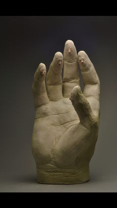 a sculpture of a hand with two hands on it's sides and one in the middle