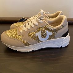 These Beautiful Sneakers Are Brand New And Never Worn. They Have Been Kept In Their Box In A Smoke-Free And Clean Environment. Feel Free To Ask Any Questions! Casual Glitter Sneakers With Round Toe, Gold Glitter Low-top Sneakers, Gold Low-top Sneakers With Glitter Accents, Casual Low-top Sneakers With Glitter Print, Gold Glitter Lace-up Sneakers, Casual Gold Glitter Sneakers, Trendy Gold Glitter Sneakers, Casual Sneakers With Glitter Print, Casual Lace-up Sneakers With Glitter Print