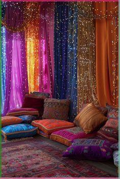 a room filled with lots of different colored pillows and drapes on the wall above it