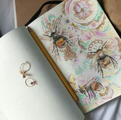 an open notebook with two bee rings on it