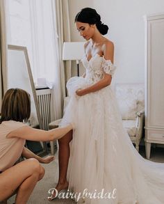 a woman in a wedding dress getting ready to go into her bridal gown for the ceremony