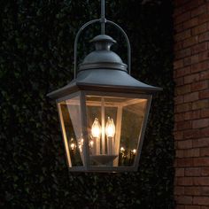 a light hanging from the side of a brick building