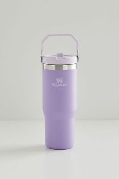 a purple insulated cup sitting on top of a white table