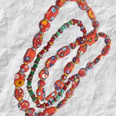 Immerse yourself in the vibrant hues and intricate artistry of this stunning 19" ethnic beaded necklace! 💎 Meticulously handcrafted with a double layer of ceramic beads and authentic African Krobo beads from Ghana, this piece exudes bohemian chic.The vibrant color palette, ranging from fiery reds to deep indigos, creates a mesmerizing rainbow effect that will elevate any outfit. 🌈 Each bead is individually painted by skilled artisans, making every necklace a unique work of art. Whether dressing up for a special occasion or adding a pop of color to your everyday look, this necklace is sure to turn heads. 💫 Embrace global artistry and sustainable fashion with this one-of-a-kind piece that celebrates the rich cultural heritage of Africa. Elevate your jewelry collection with this vibrant et Traditional Multicolor Wooden Beaded Necklace, Traditional Multicolor Wooden Beaded Necklaces, Colorful Beads For Rituals And Festivals, Artisan Red Beaded Necklace For Festivals, Festive Bohemian Hand-strung Beaded Necklaces, Artisan Orange Beaded Necklaces For Festivals, Artisan Red Beaded Necklaces For Festivals, Artisan Red Oval Beads, Handmade Red Beaded Necklaces For Festivals