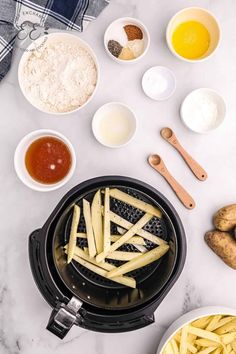 french fries are being cooked in an air fryer next to other ingredients and utensils