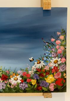 an oil painting of flowers and a bee on a blue sky with clouds in the background