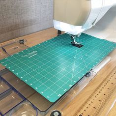 there is a sewing machine on top of a cutting mat that has been cut into pieces