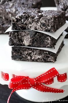 three chocolate brownies stacked on top of each other with a red ribbon around them