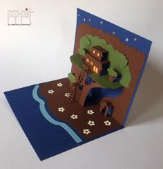 an open card with a house and trees on it