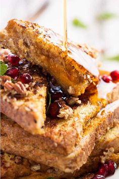 toasted french toast with fruit and nuts being drizzled on top