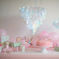 a pink birthday party with balloons, cake and decorations