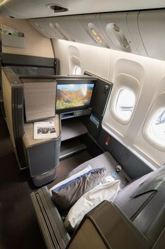 the inside of an airplane with two seats and a flat screen tv on one side