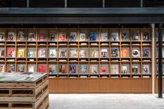 the bookshelves are filled with many different types of books and magazines on wooden pallets