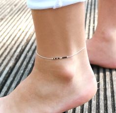 This minimalist ultra thin anklet is made with sterling silver snake chain adorned with Black miyuki beads.➵ Perfect to wear alone or for layering with more anklets.➵ More anklets : https://www.etsy.com/shop/silverbirdjewels/items?section_id=21837916--*--*--*--*--*--*--*--*--*--*--*--*--*--*--*--*--*--*--∞ SIZE ∞- length: Adjustable bracelet - around 20 cm (7,9 in) - 25 cm (9,8 in).If you like another length please make a note when you "check out" (I can make it for children) .∞ MATERIAL ∞- Ster Black Anklet, Silver Anklets Designs, Leather Anklets, Silver Ankle Bracelet, North Star Necklace, Gold Disc Necklace, Anklet Designs, Jewelry Delicate, Star Necklace Gold