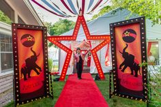 a red carpeted walkway leading to two large lighted signs with an elephant on them