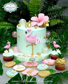 a cake decorated with pink flamingos and cookies