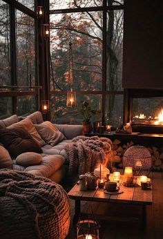 a living room filled with lots of furniture next to a window covered in candles and blankets