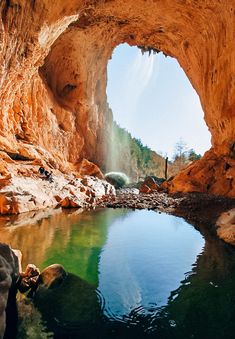 the water is clear and blue as it flows through an opening in a rock formation