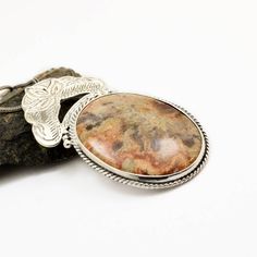 "Crazy lace agate necklace sterling silver large oval lace agate pendant orange brown beige antique bohemian style, artisan boho jewelry A beautiful large oval crazy lace agate stone with hues of brown, beige and orange in sterling silver statement pendant. Lovely autumn colors and winter colors too. The stone is set inside a bezel and framed with braided wire . On top of it there is an engraved antique floral pattern. I have oxidized it to bring out the details and achieved this bohemian look T Handmade Jasper Oval Necklaces, Handmade Oval Jasper Necklaces, Handmade Jasper Oval Necklace, Bohemian Jewelry With Oval Pendant Natural Stones, Handmade Oval Jasper Necklace, Bohemian Agate Round Pendant Jewelry, Bohemian Sterling Silver Oval Pendant Necklace, Silver Oval Bohemian Necklaces, Bohemian Agate Necklace With Large Pendant