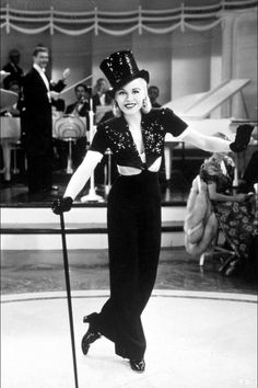 a woman with a top hat and cane posing for the camera