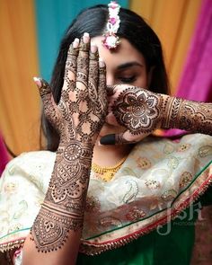 a woman holding her hands up to show the hendi on her left hand and right hand