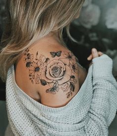 a woman with a flower tattoo on her back shoulder and neck is looking at the camera