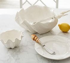 a white plate with a silver fork and some lemons on the table next to it