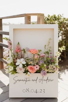 a white box with flowers inside sitting on a wooden deck