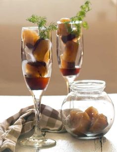 two glasses filled with drinks sitting on top of a table