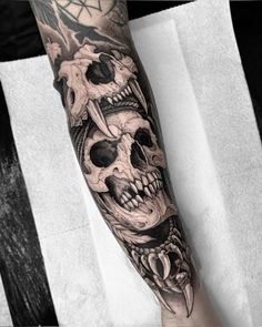 a man's arm with tattoos and skulls on it