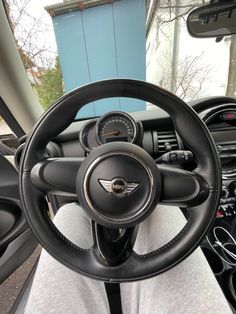 the interior of a car with steering wheel, dashboard and gauges on both sides