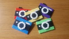 four pieces of plastic beaded camera sitting on top of a wooden table next to each other