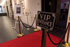 a red carpeted hallway with black and white sign on it that says, vip entrance