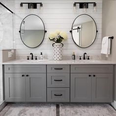 a bathroom with two sinks and mirrors on the wall next to each other in front of a walk in shower