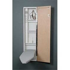 an open white cabinet with shoes on the door and a pillow in front of it