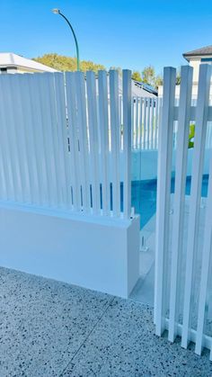 a white fence next to a swimming pool