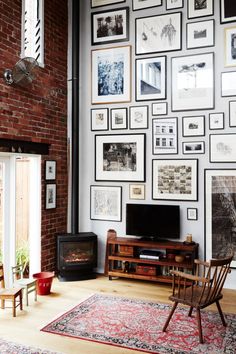 a living room with pictures on the wall and a television in the corner next to a fire place