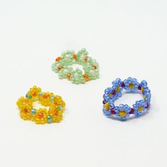 three beaded bracelets sitting next to each other on a white surface with beads