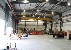 an empty warehouse with lots of furniture and lighting on the ceiling is pictured in this image