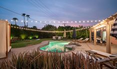 a backyard with a pool and string lights