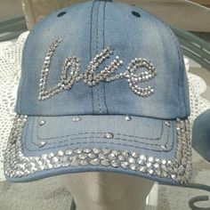 a blue hat with the word love written in silver sequins on it's peak