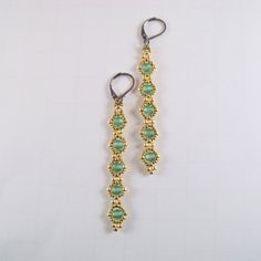 "A pretty pair of glass beaded light blue linear earrings were woven with tiny 24k gold plated finish glass seed beads. The dangle earrings hang from tarnish resistant stainless steel lever back ear wires. Earrings measure: 3.00\" inches ( 7.62 cm ) long from ear hole to bottom of beads. https://www.etsy.com/shop/FMGuyDesigns" Gold Beaded Drop Earrings, Adjustable Gold Bead Drop Earrings, Gold Long Drop Beaded Earrings With Ear Wire, Adjustable Beaded Gold Crystal Earrings, Handmade Gold Beaded Long Drop Earrings, Adjustable Gold Beaded Crystal Earrings, Linear Earrings, Toms River Nj, Beading Ideas