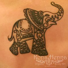 an intricately designed elephant tattoo on the back of a woman's shoulder and chest