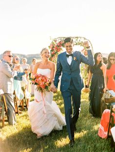 a bride and groom walking down the aisle after their wedding ceremony at an outdoor venue