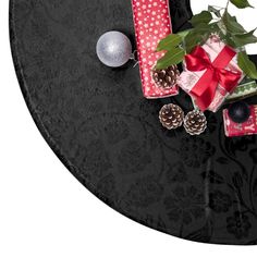 a black table with presents and ornaments on it's side, including an ornament